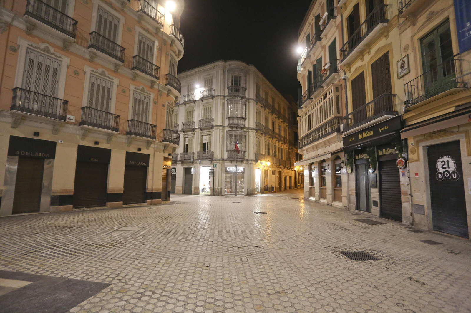 El coronavirus dibuja una noche desierta en el centro de Málaga, en fotos