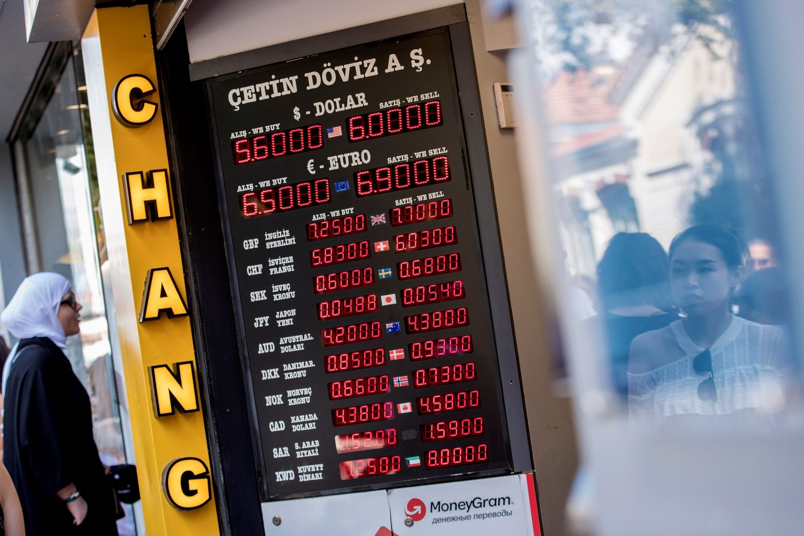 Una mujer contempla el luminoso de una oficina de cambio de divisas en una calle comercial de Estambul.