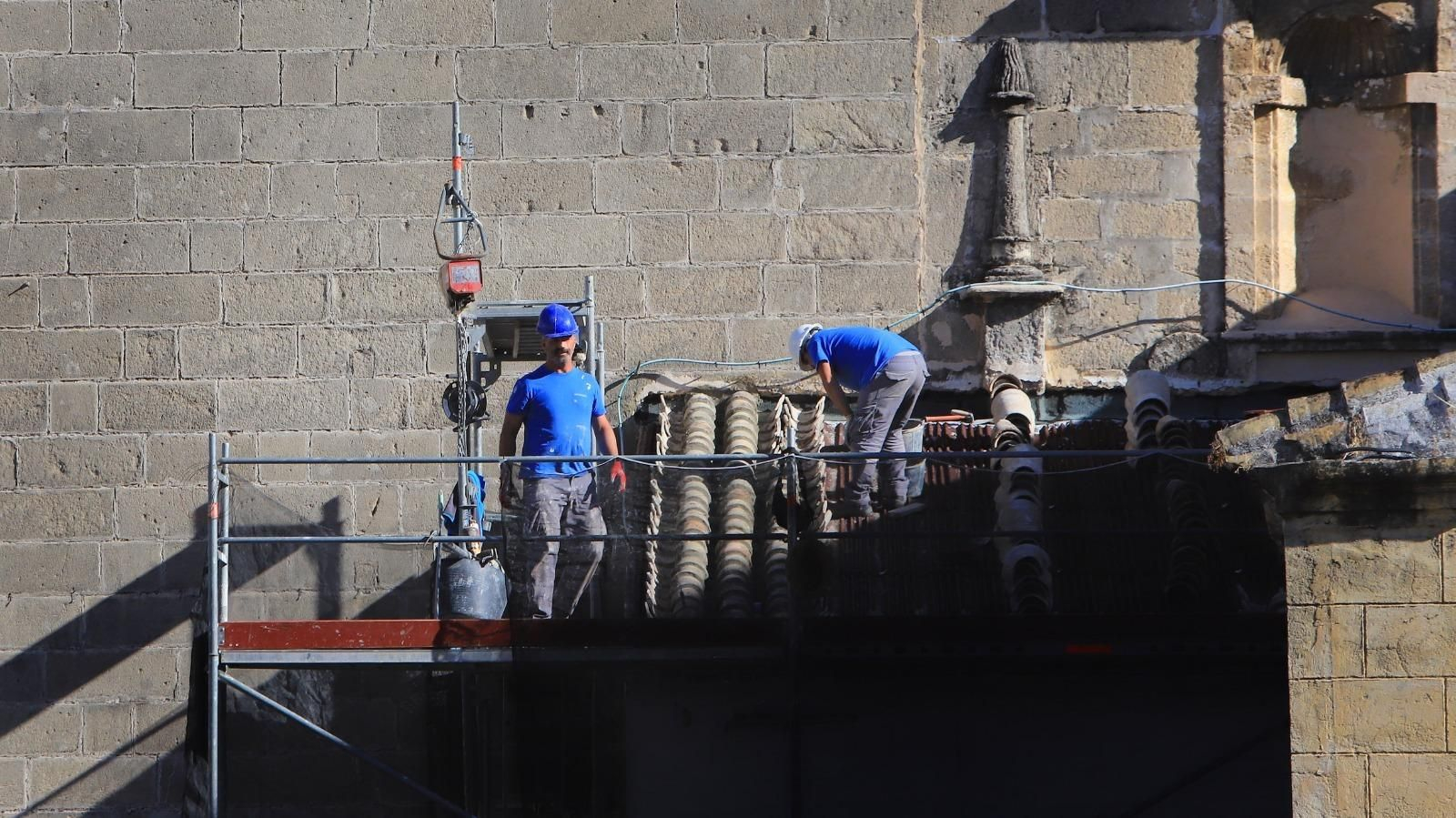 Trabajadores de la construcción en la obra de reparación del techado de la casa de la hermandad del Rocío.