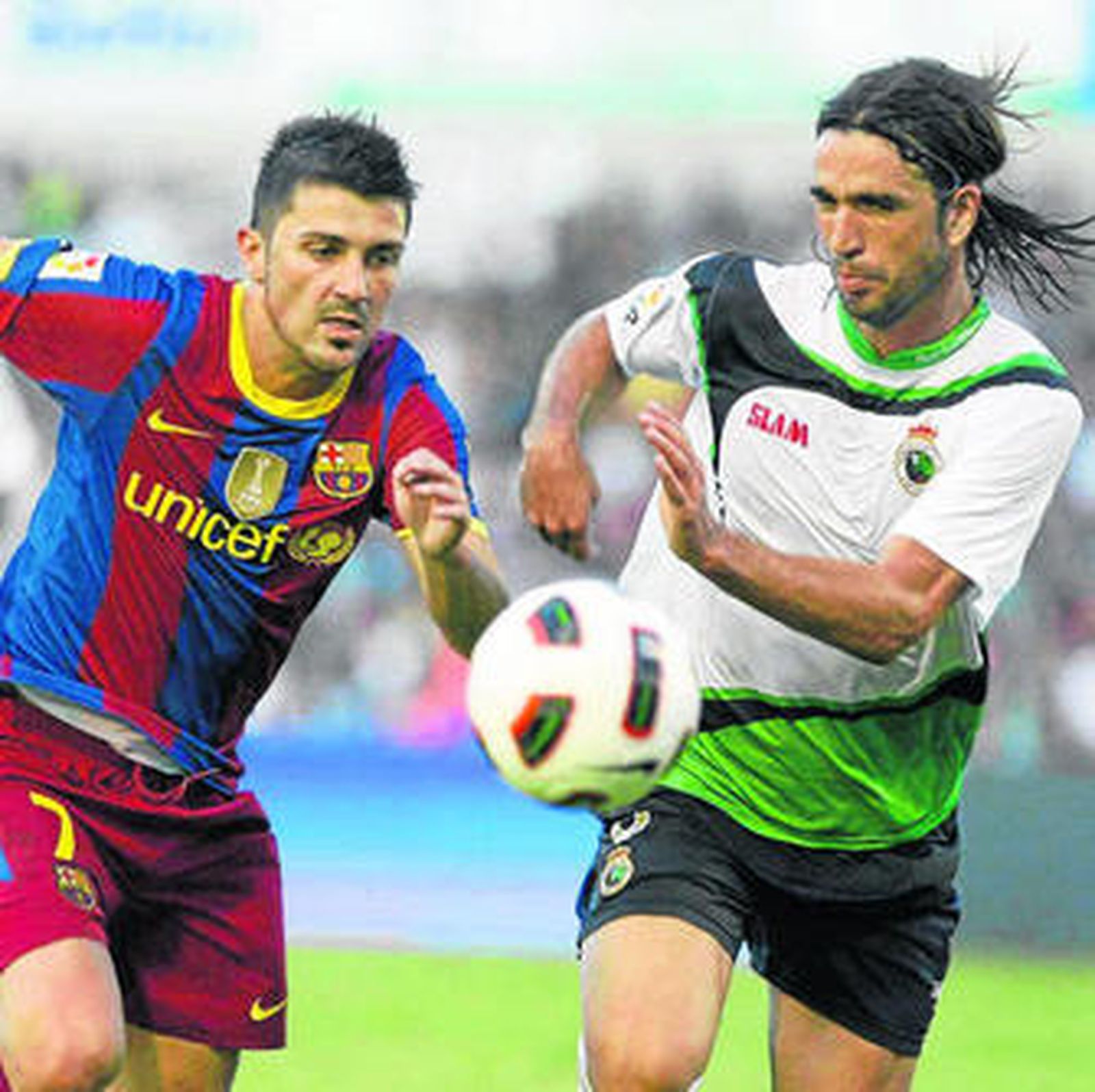 Domingo Cisma pugna un balón con el azulgrana Villa en El Sardinero.