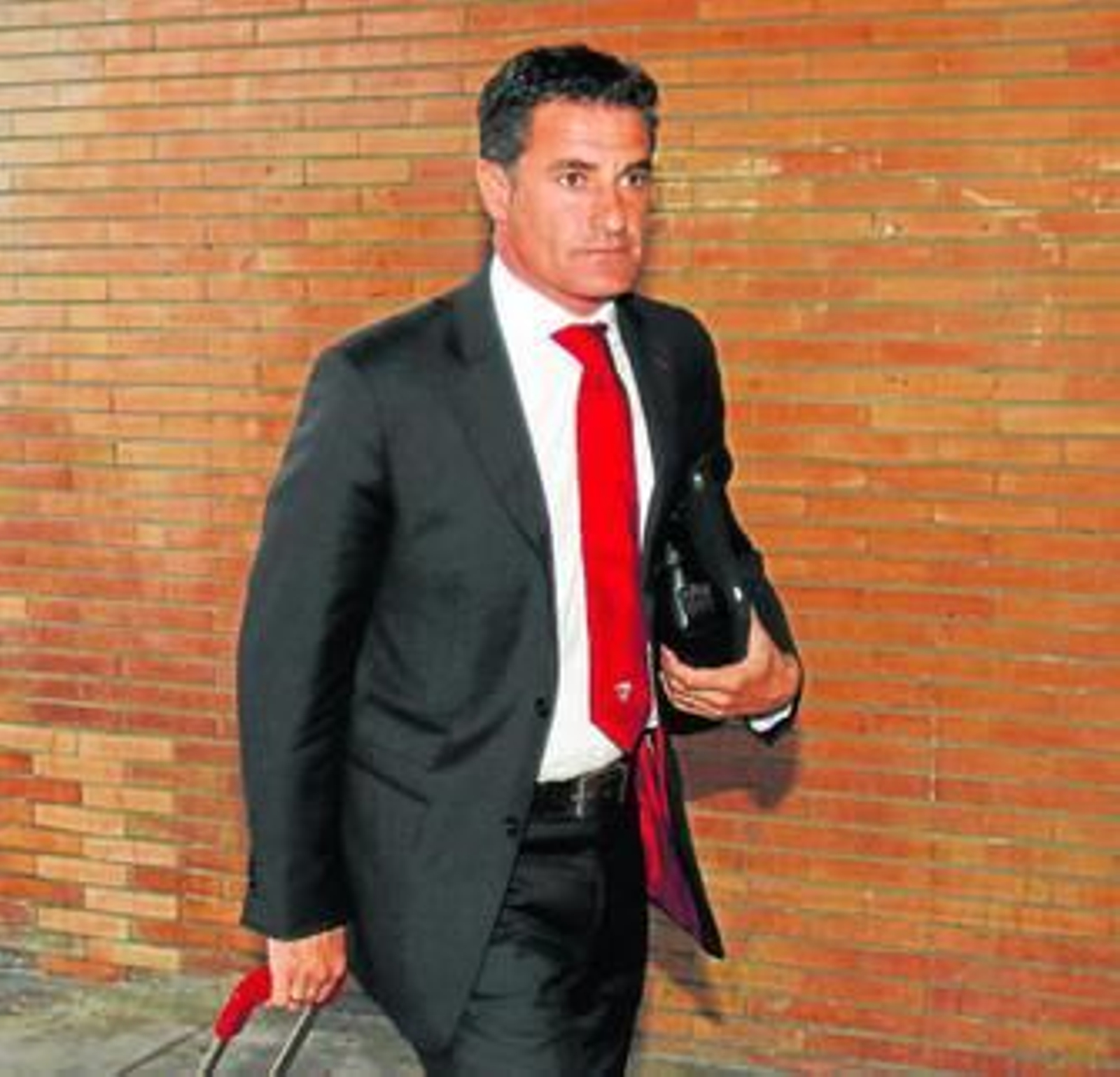 Míchel, con rostro serio, tira de su maleta en la estación de Santa Justa.