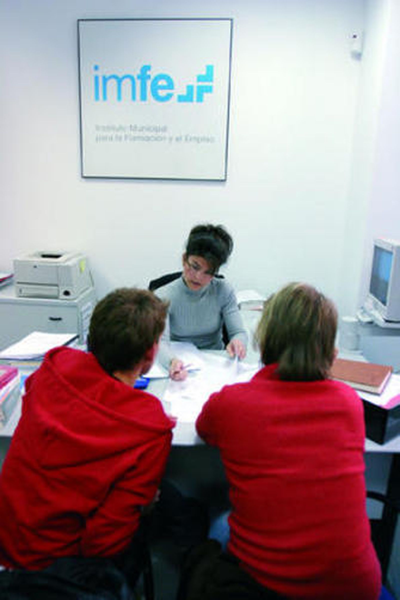 Una técnico del IMFE asesora a dos personas.