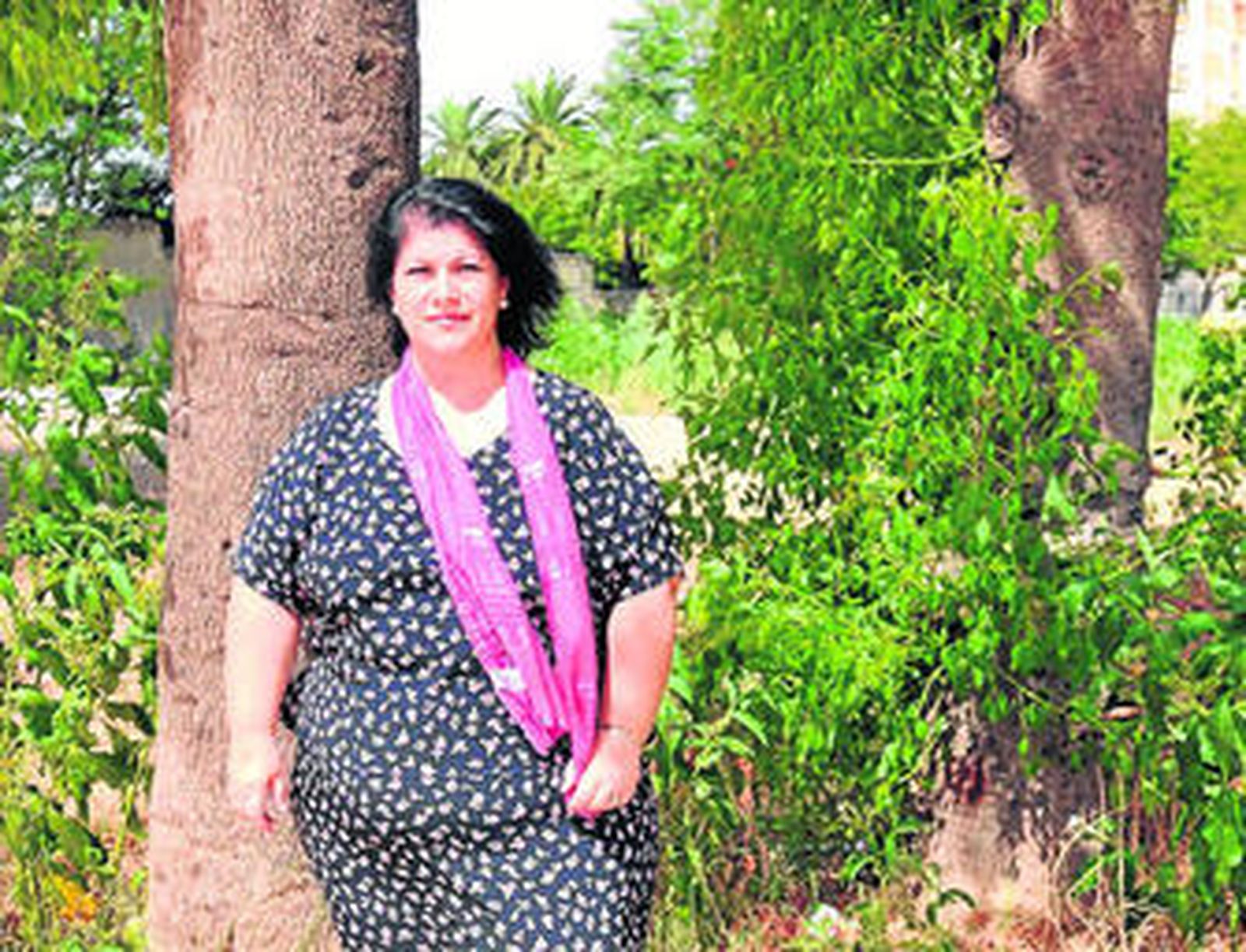 Rosa Saborido ante la zona del patio donde hay que quitar la maleza.