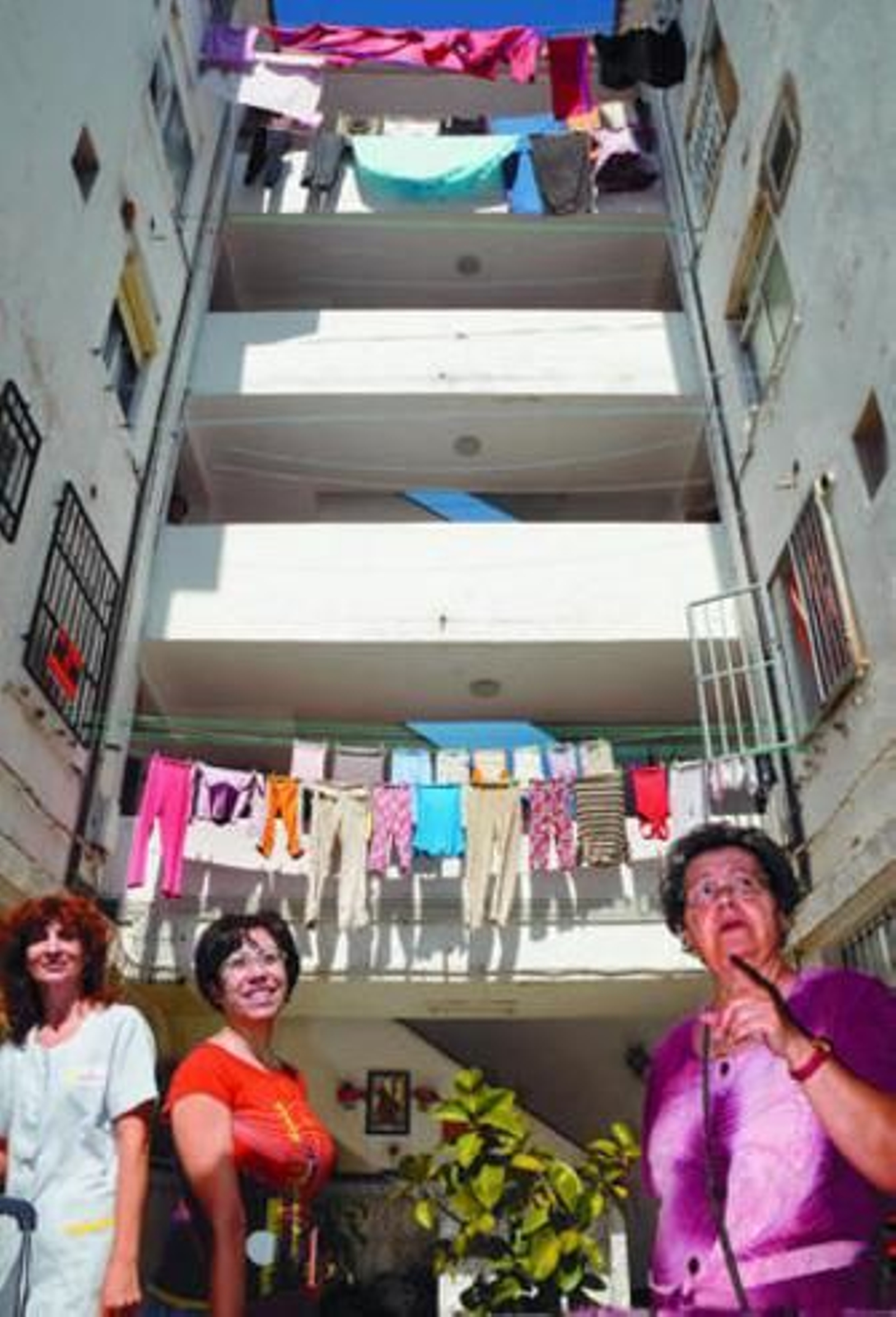 Tres vecinas posan en el patio de uno de los bloques que serán derruidos en Regiones Devastadas.