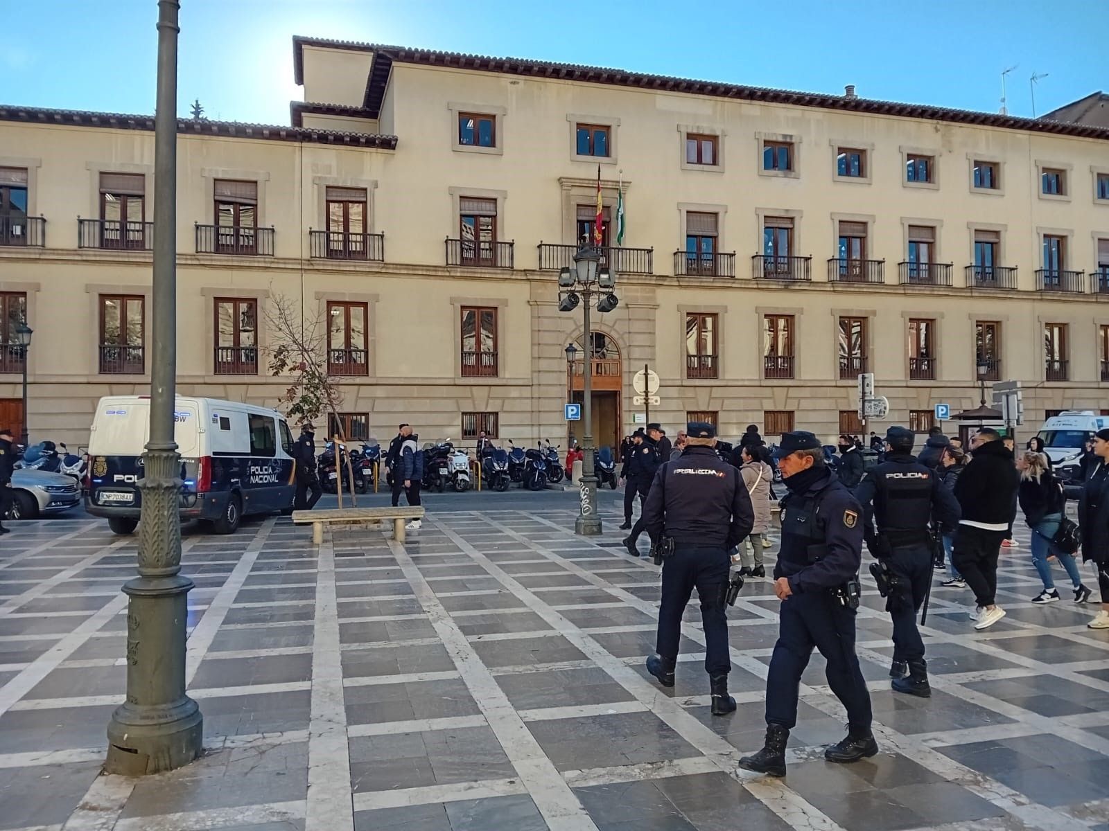 Familiares de la víctima y agentes en Plaza Nueva, a la salida del furgón policial donde iba el acusado de matar a un hombre en Churriana de la Vega