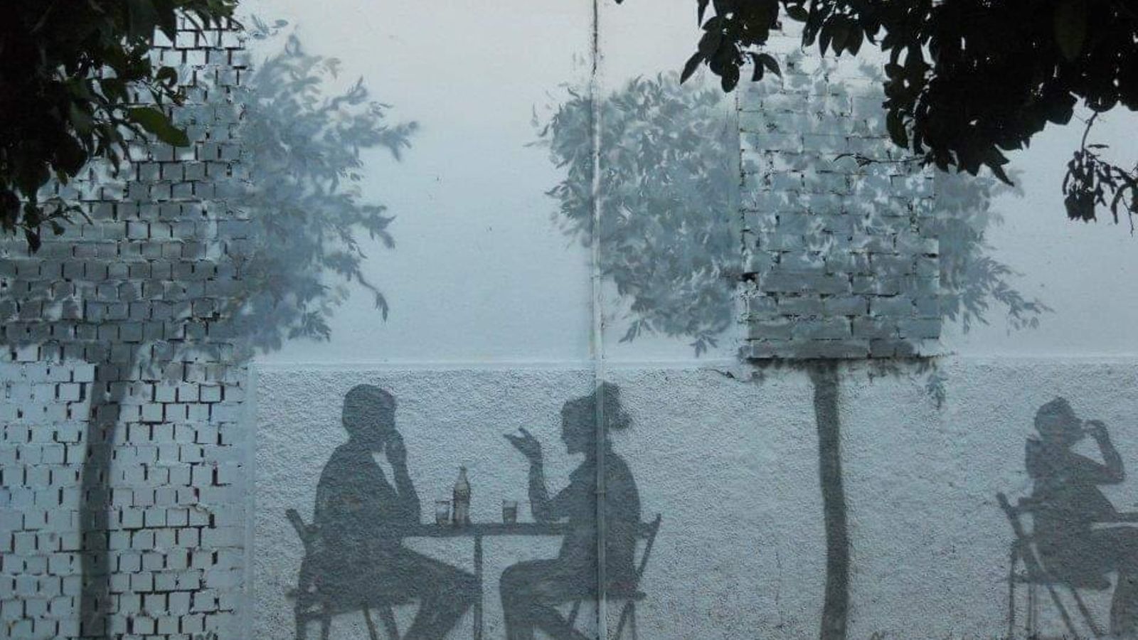 Tranpantojo en gris de la calle Calatrava que recrea la terraza de un bar.
