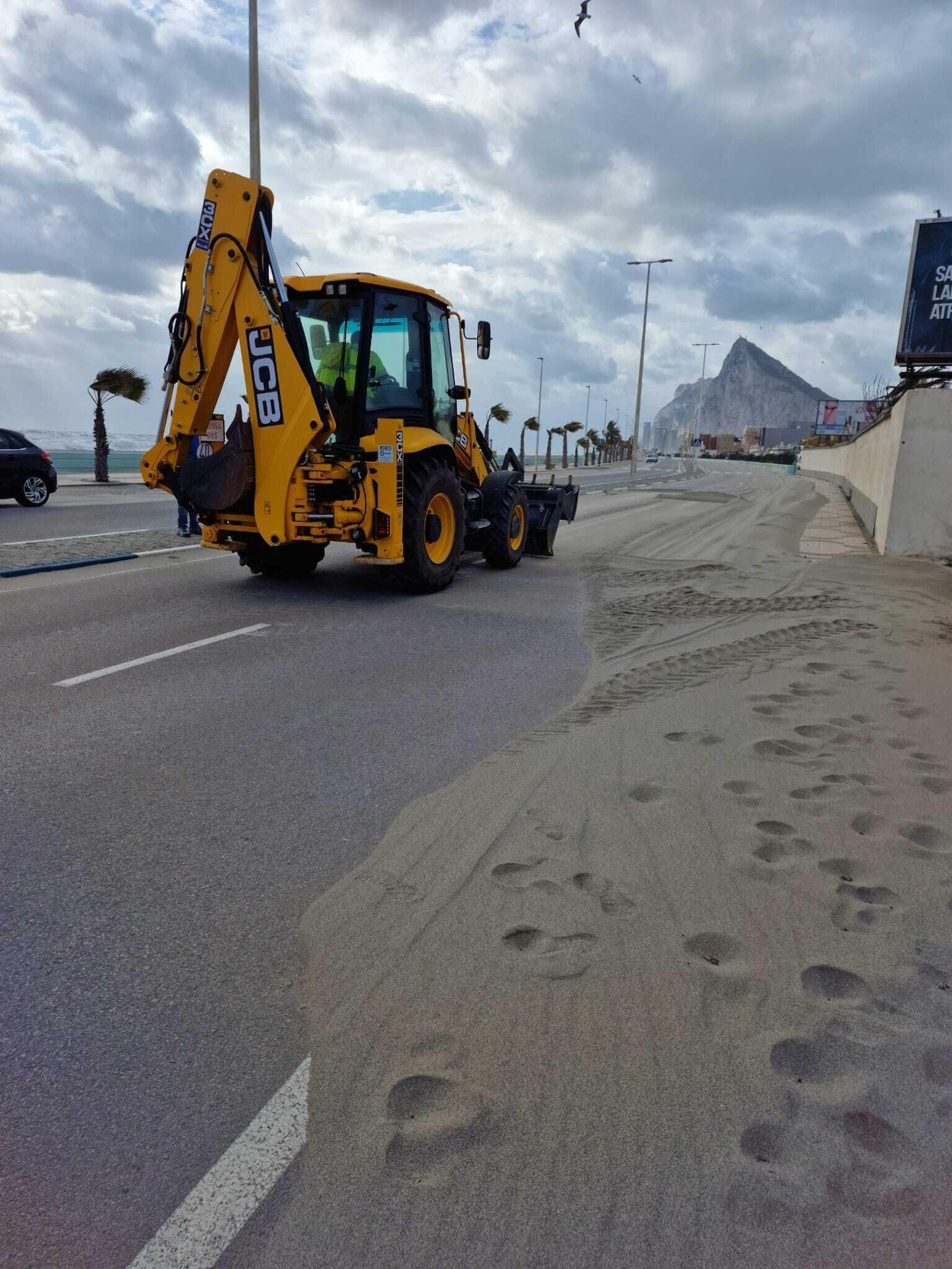 Excavadora retirando la arena de la calzada