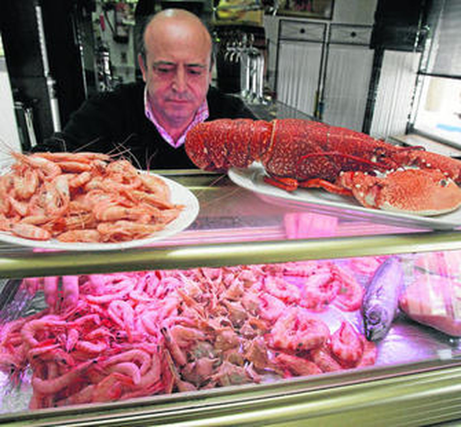 Víctor Abad coloca el marisco de Sanlúcar en la vitrina de su establecimiento.