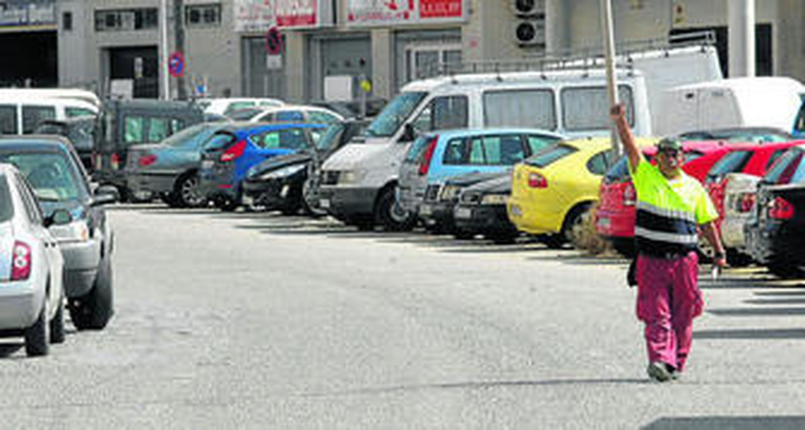 Imagen de un 'vovi' ordenando una zona de estacionamiento en la ciudad.