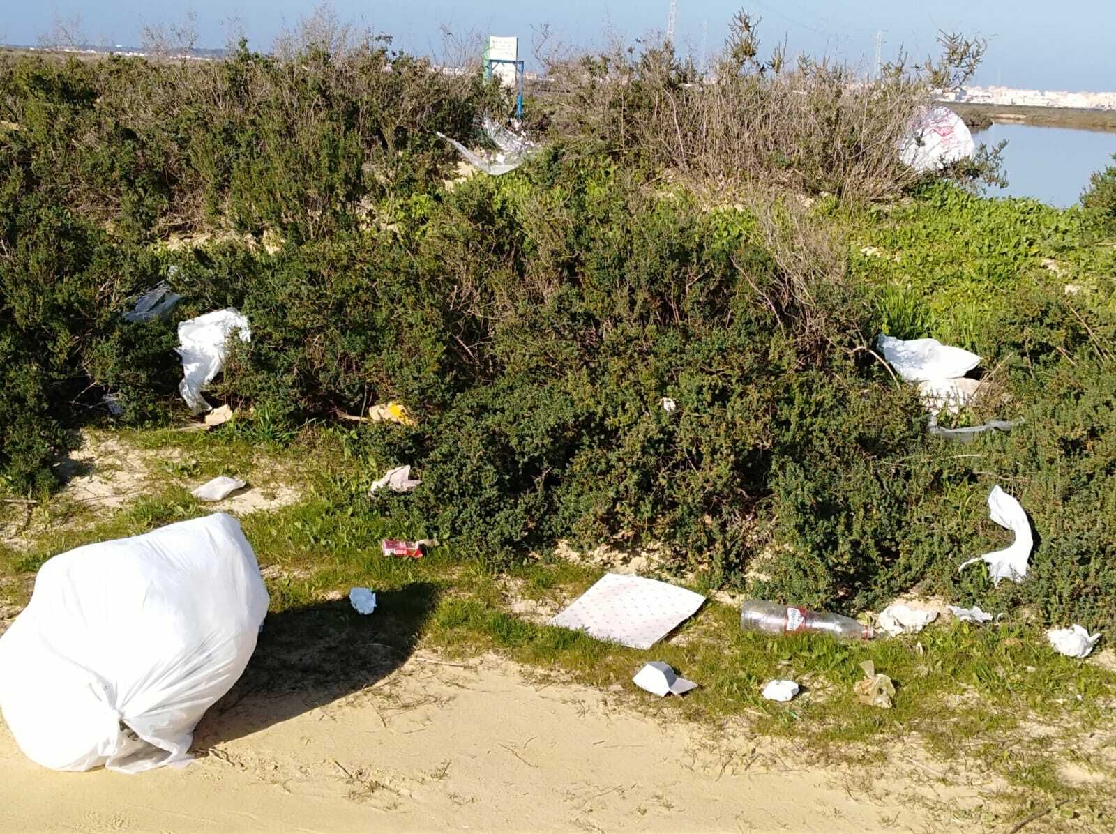 Plásticos y papeles junto al río en la zona de las salinas.