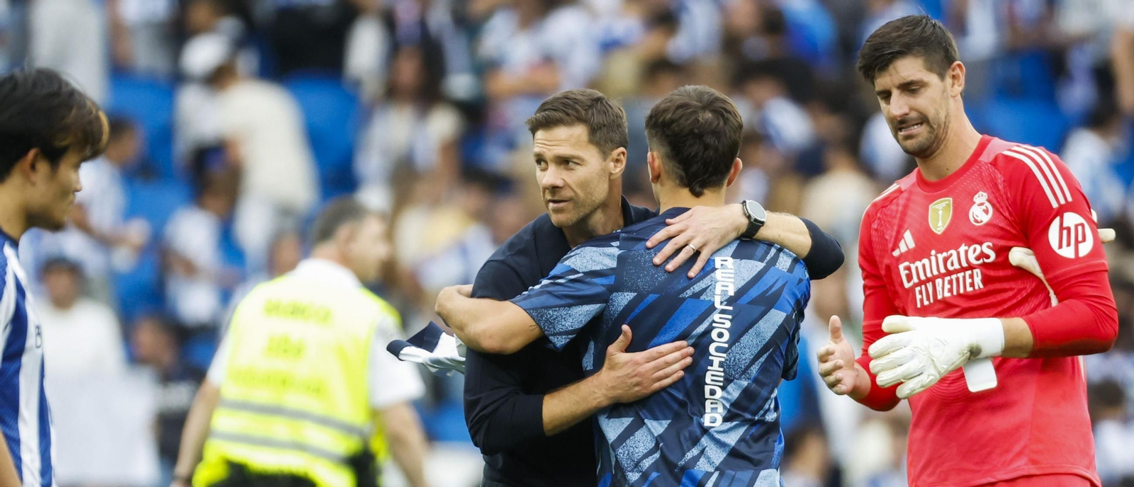 Xabi Alonso recibe el abrazo de un futbolista de la Real Sociedad en presencia de Courtois.