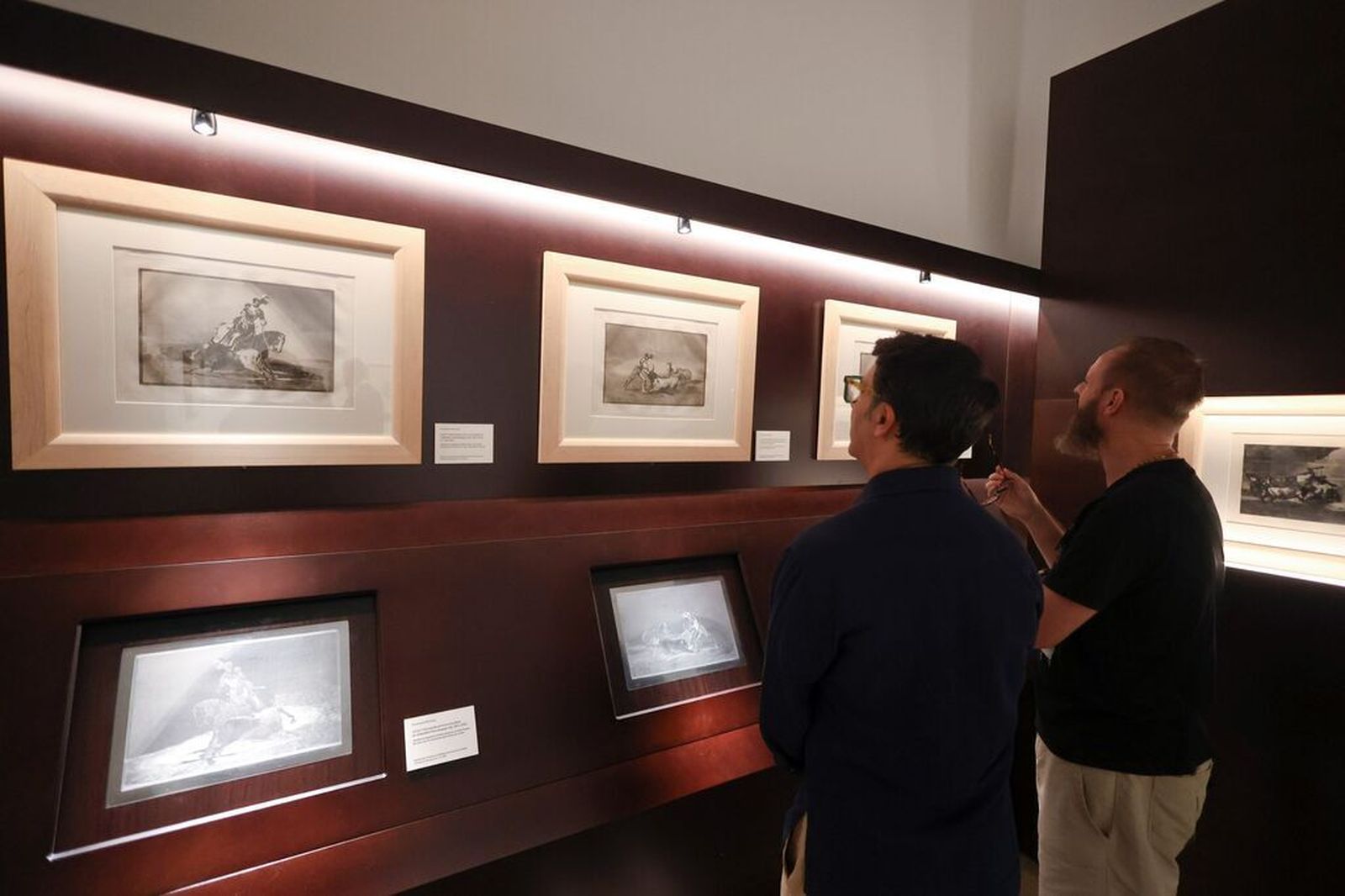 Dos asistentes observan algunas obras del ciclo ‘Leyendo imágenes: Goya, Picasso y la filosofía’ .