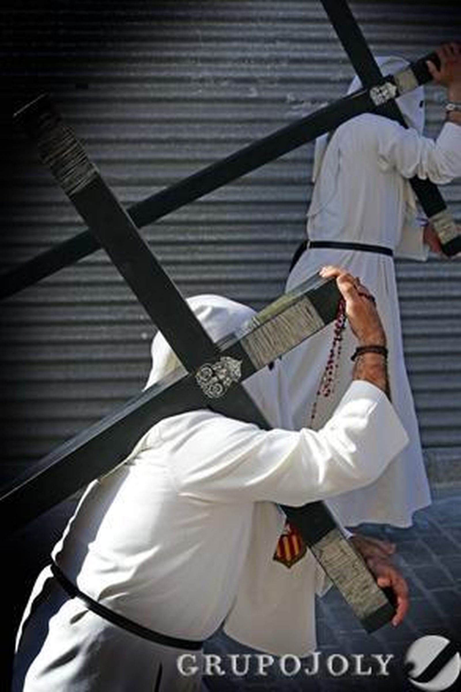 Dos hermanos de El Transporte cargando con sendas cruces de penitencia durante el inicio de la procesión.

Foto: Manuel Aranda