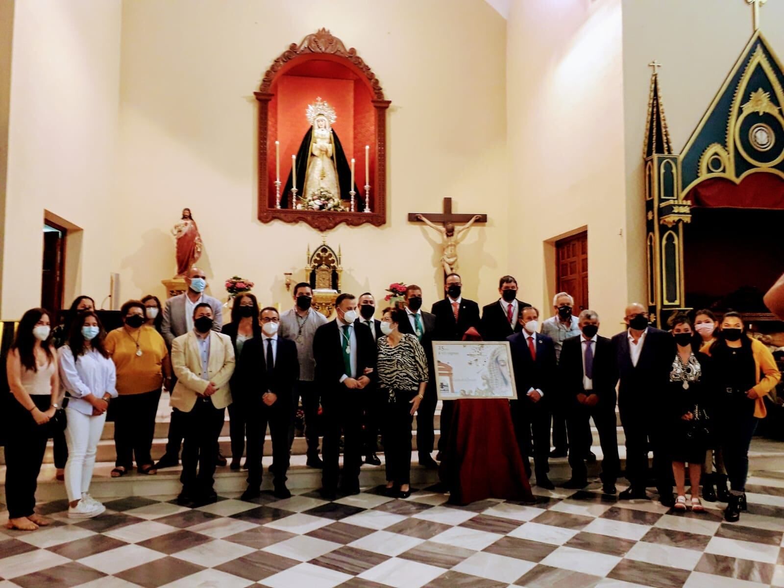 Los participantes en el acto conmemorativo posan ante el altar mayor de la capilla.