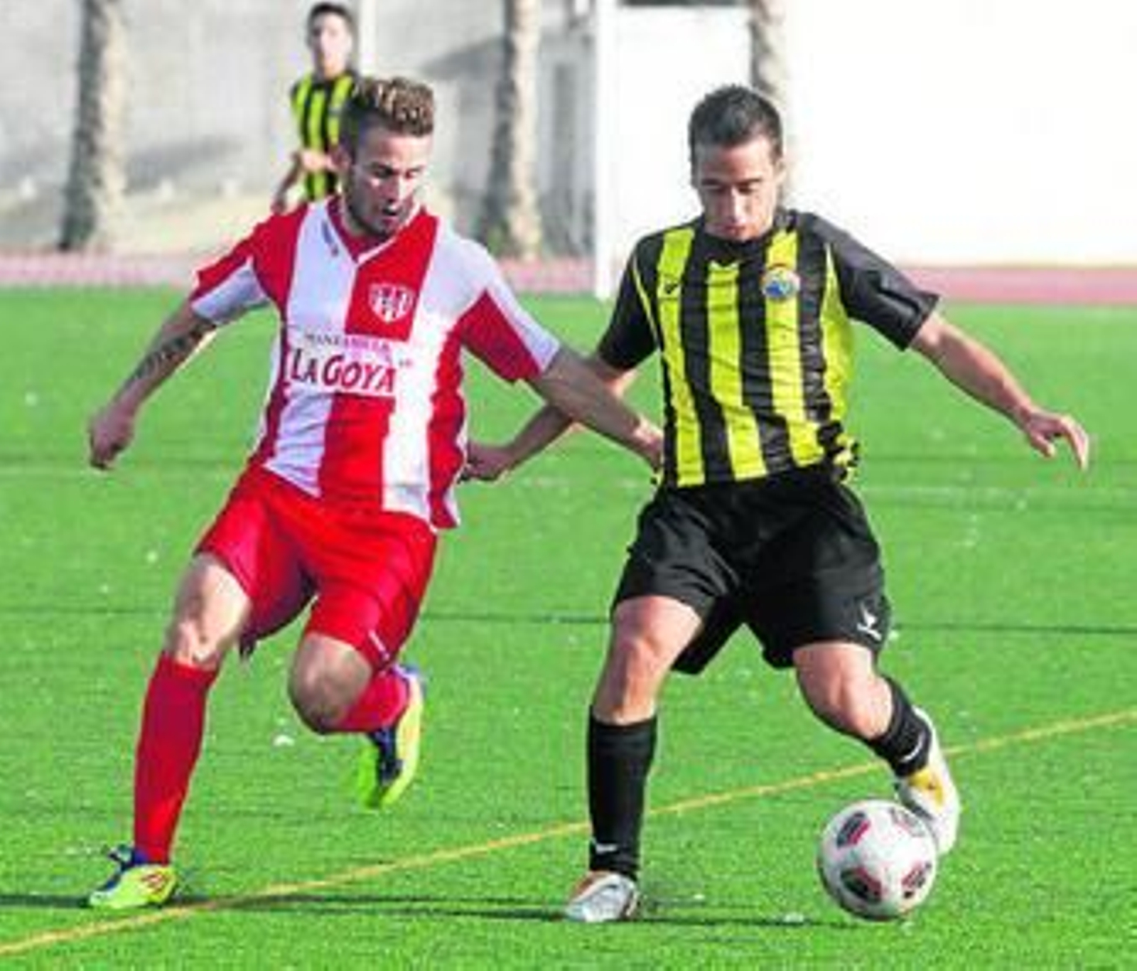 Álex Chino avanza con el balón ante la cercana marca de un rival.