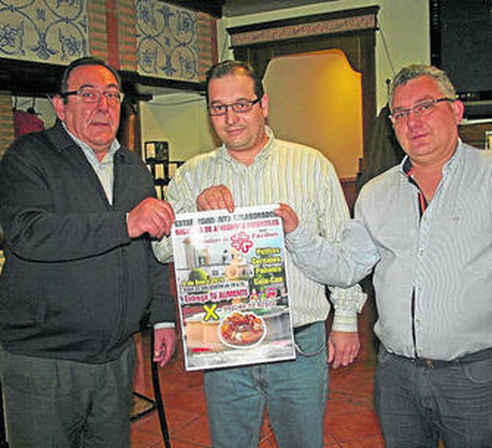 Los promotores de la actividad muestran el cartel anunciador.