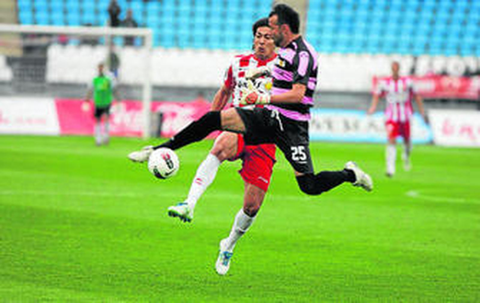 Ulloa supera a Doblas en la acción del gol.