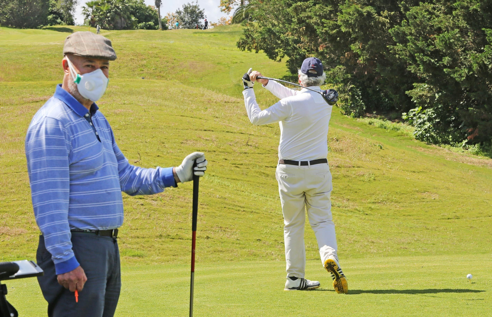 Un jugador ensaya el golpe de salida con el 'drive' mientras otro espera su turno, hoy en Sherry Golf Jerez.