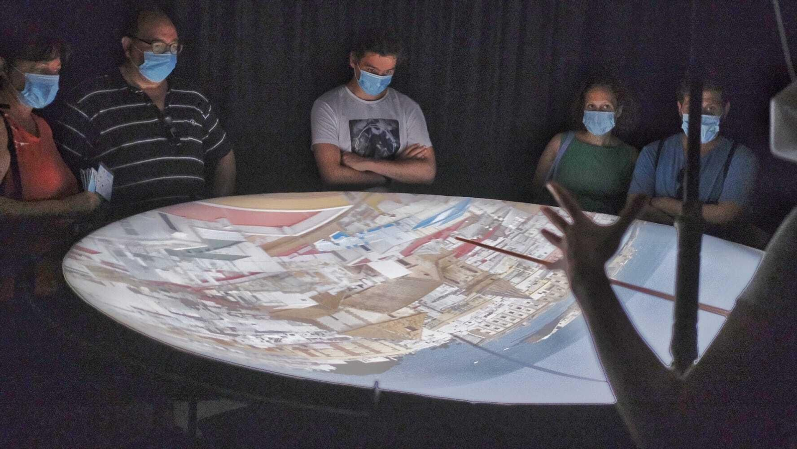 Visitantes con mascarillas atienden a las explicaciones en la Cámara Oscura.