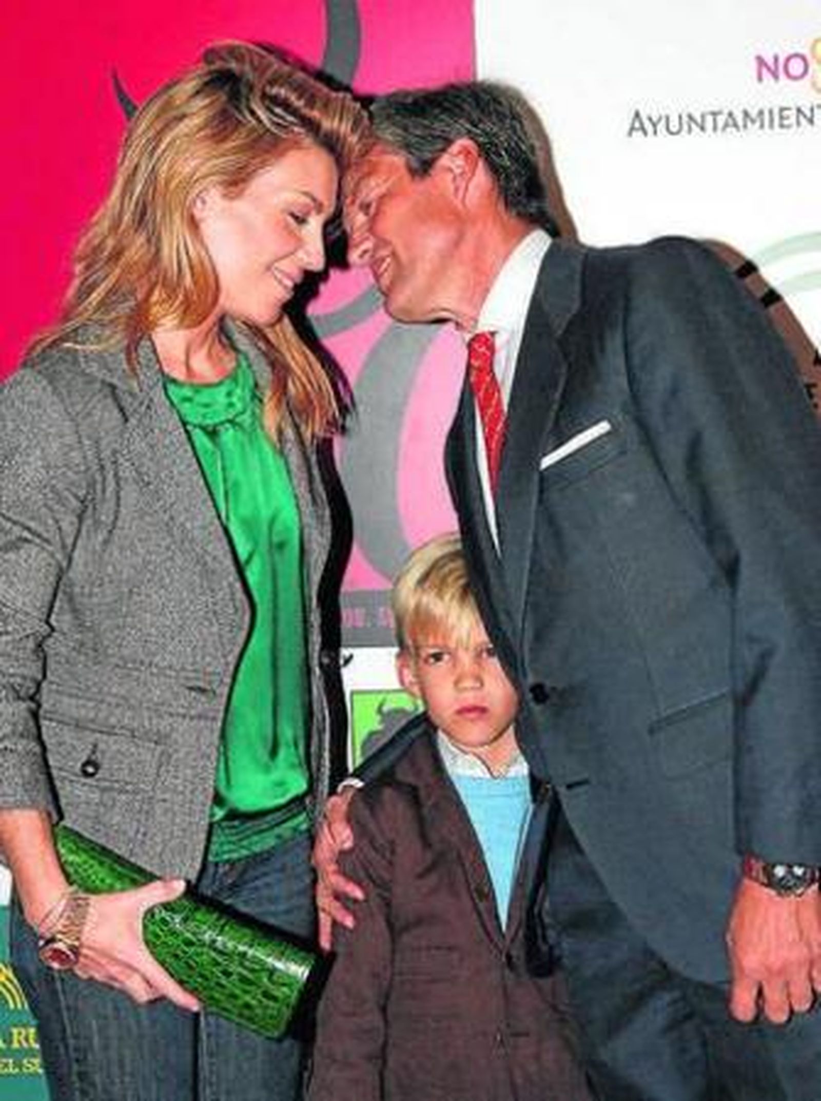 La pareja se besa en presencia de su hijo pequeño.