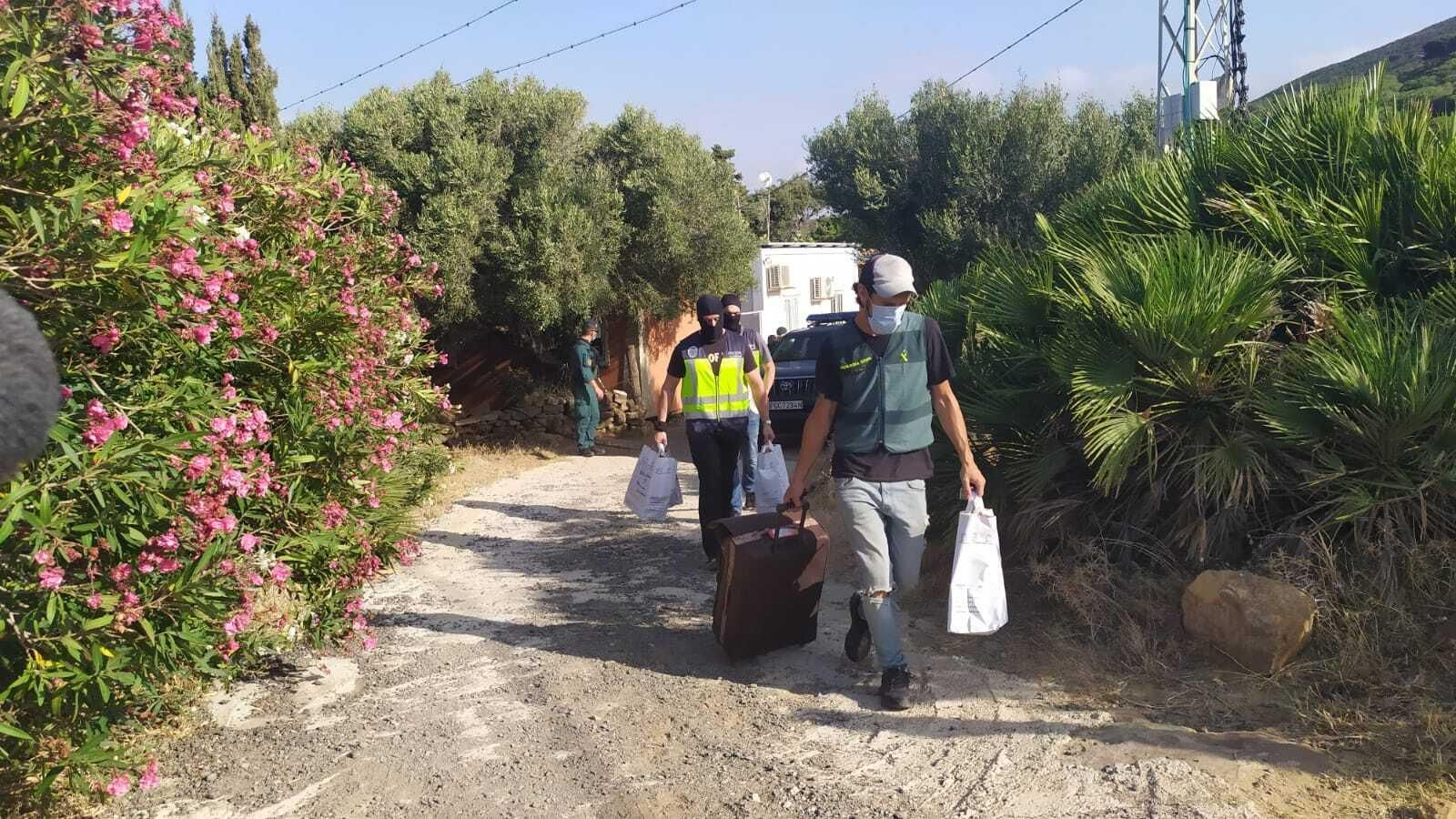 Agentes de la Guardia Civil y la Policía Nacional salen de una de las fincas registradas.