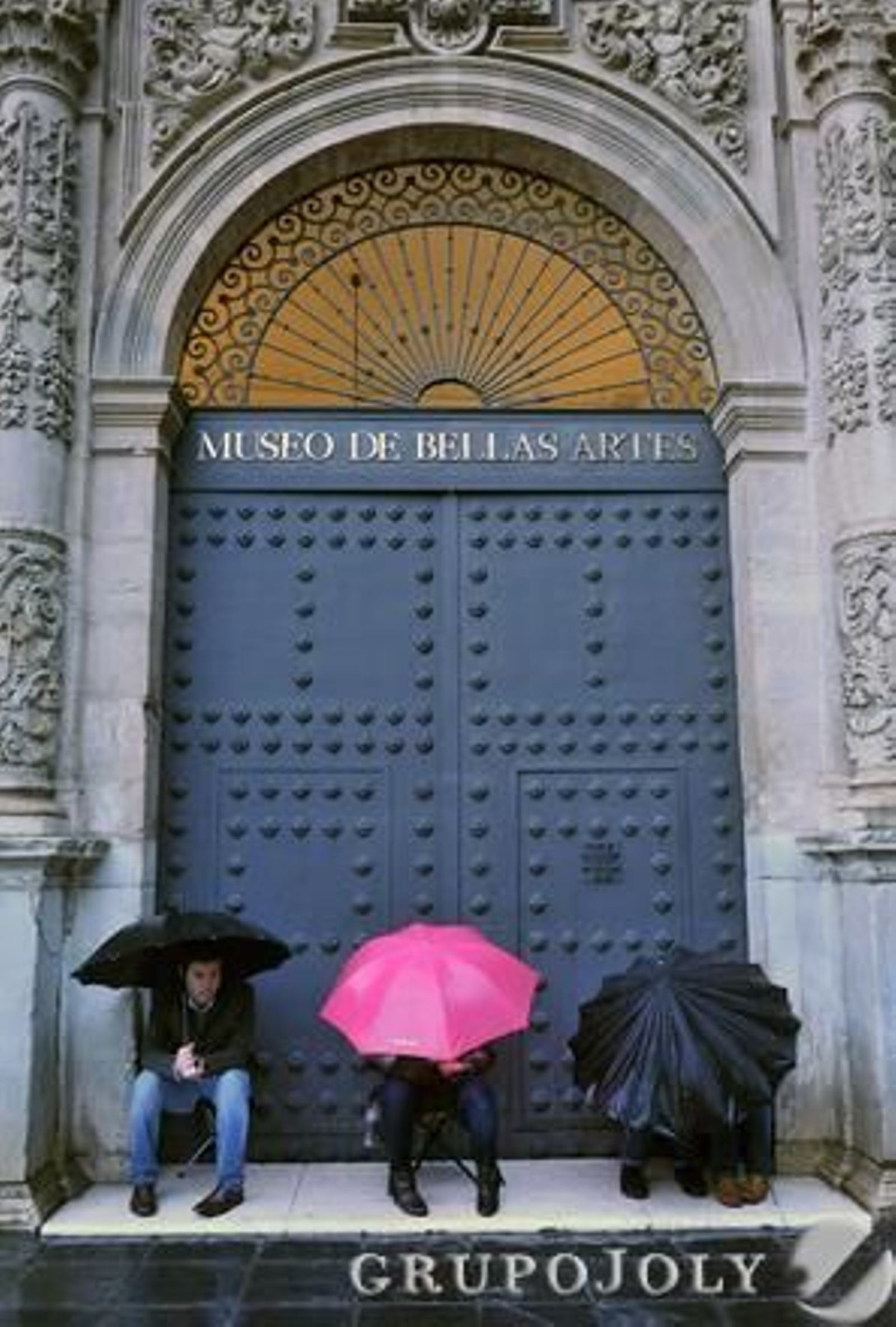 Tres jóvenes cubiertos con paraguas a las puertas del Museo de Bellas Artes.

Foto: Juan Carlos Vazquez