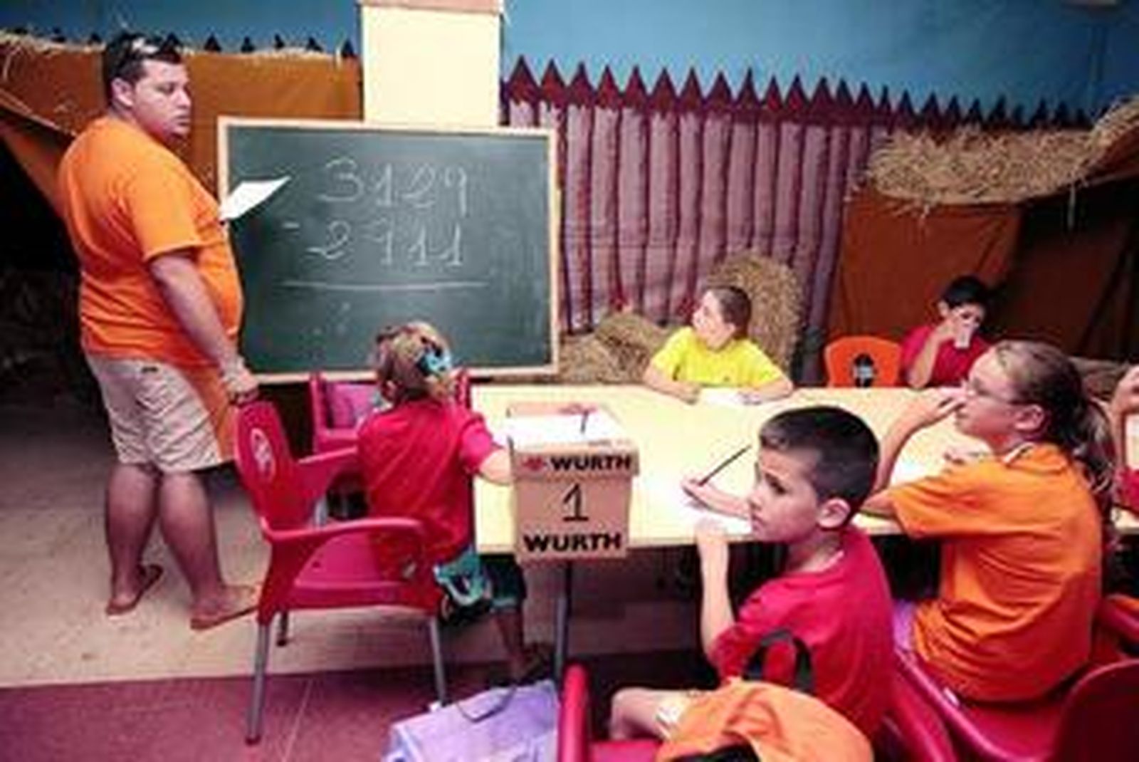 Un grupo de alumnos atiende a las explicaciones del profesor de matemáticas.