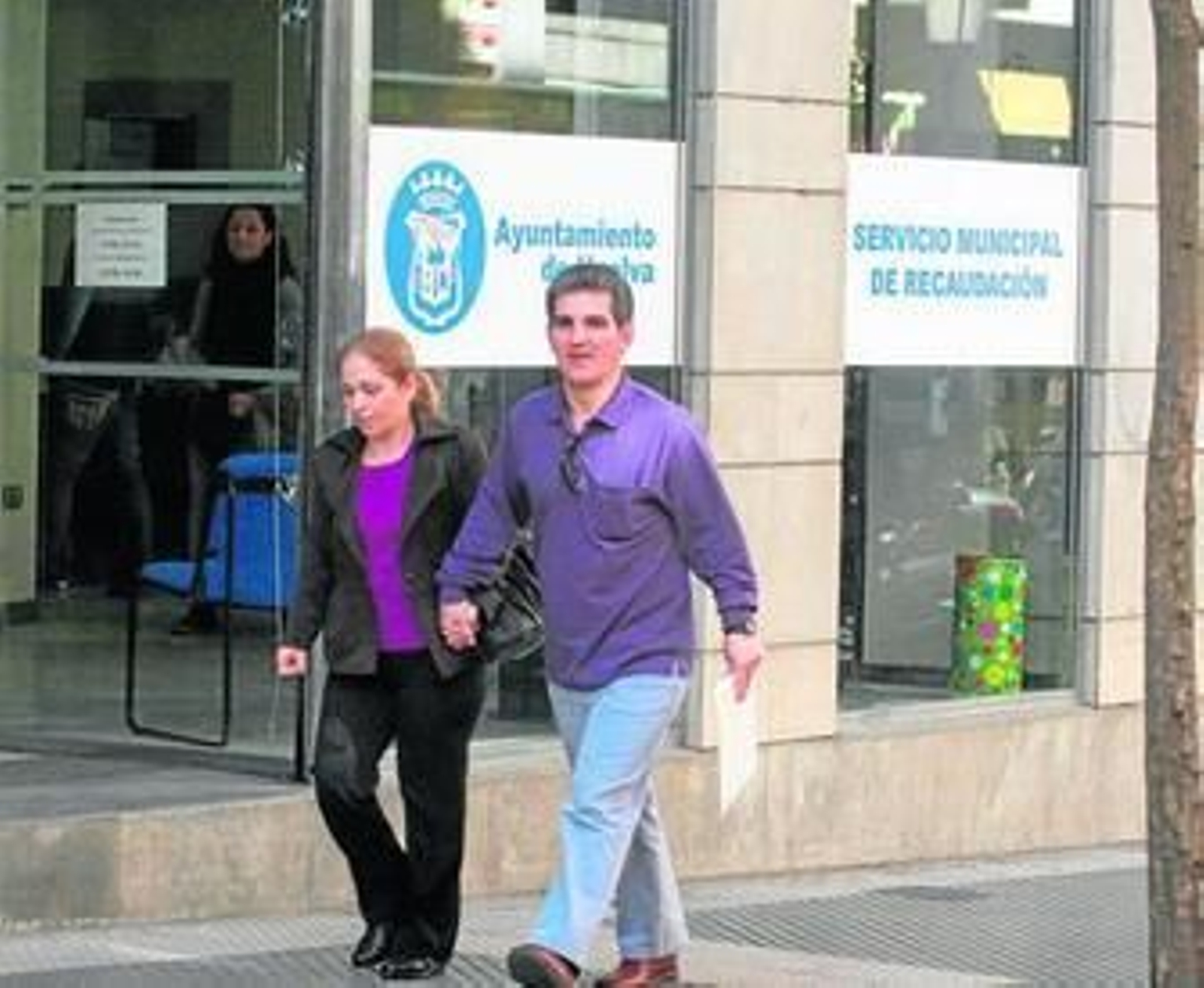 Dos transeúntes, ante la sede de la Oficina de Recaudación Municipal de la calle Puerto.