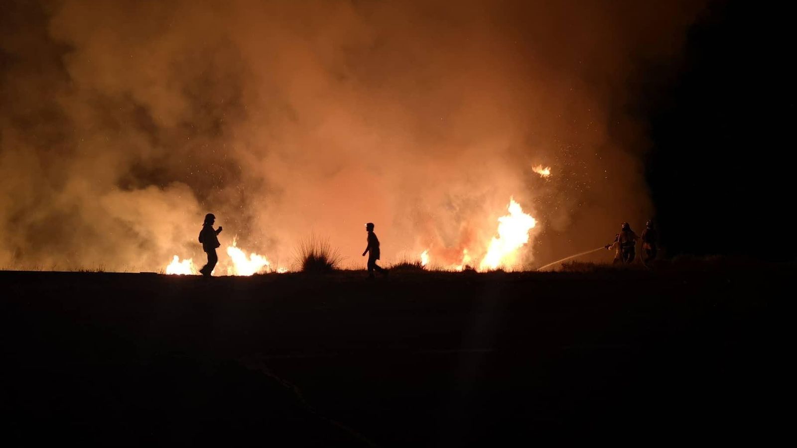 Los operarios tratando de apagar las llamas en Pradollano este martes