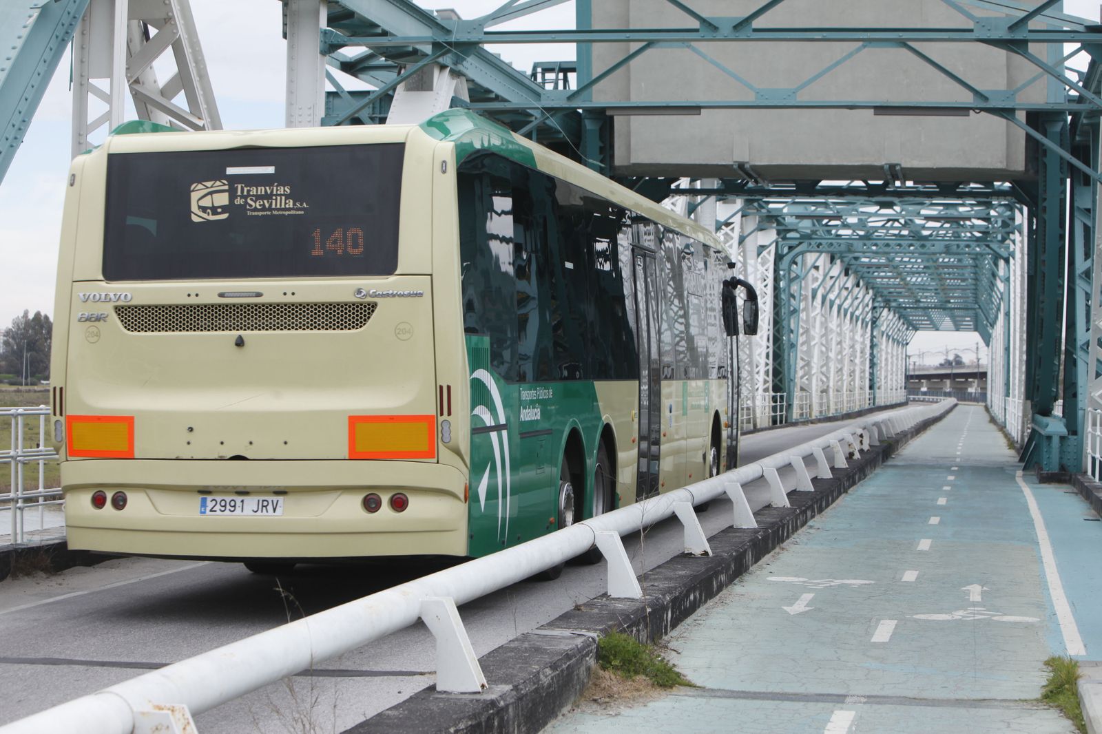Un autobús del Consorcio de Transportes, de Travías de Sevilla, por el Puente de Hierro de San Juan.