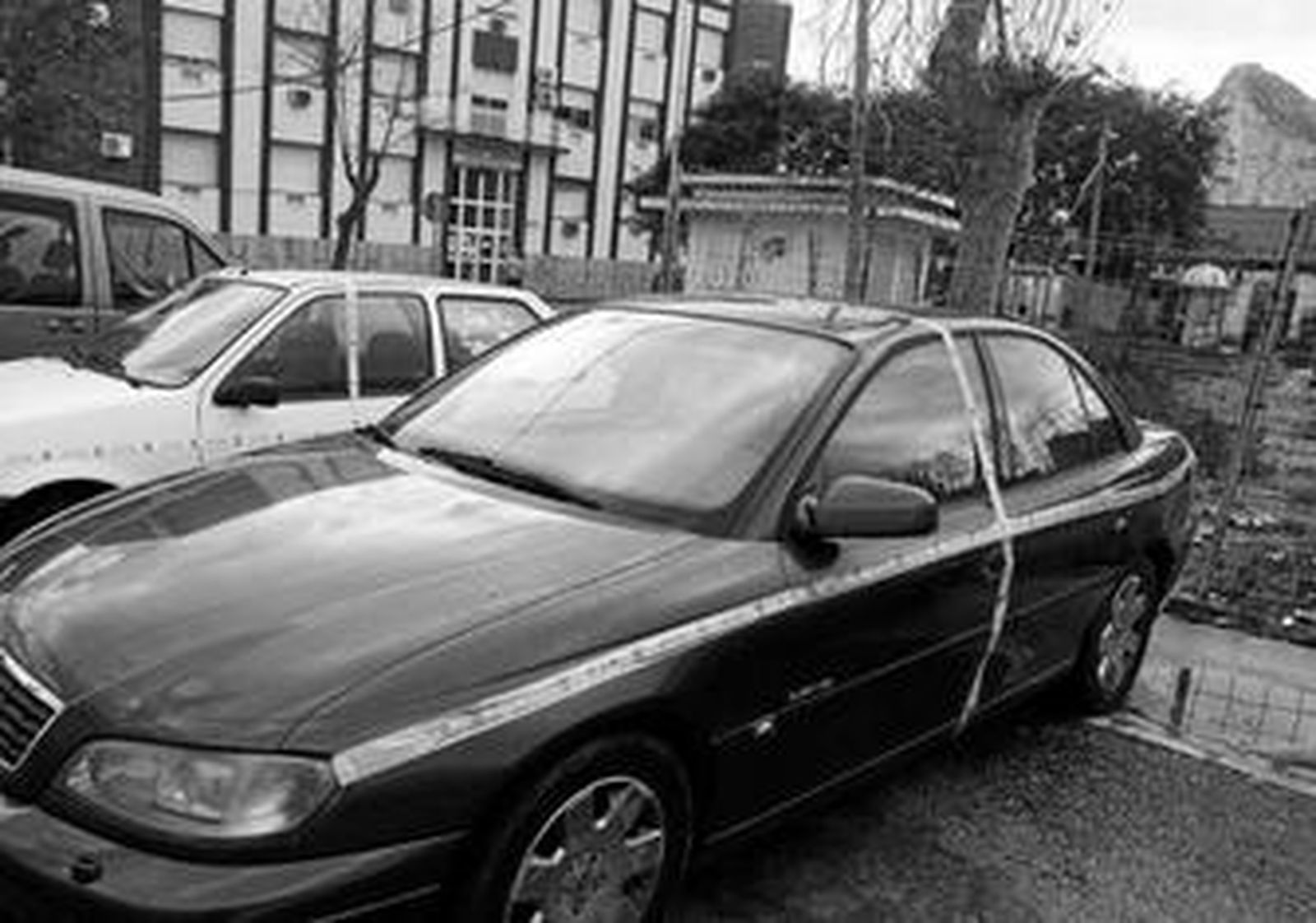 Instantánea tomada en la mañana de ayer de varios vehículos estacionados en la calle y precintados por orden judicial.