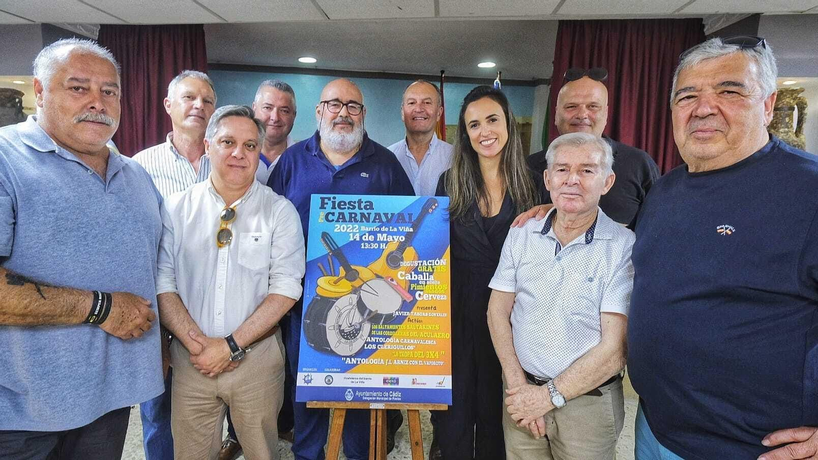Organizadores de la fiesta junto a representantes municipales posan con el cartel.