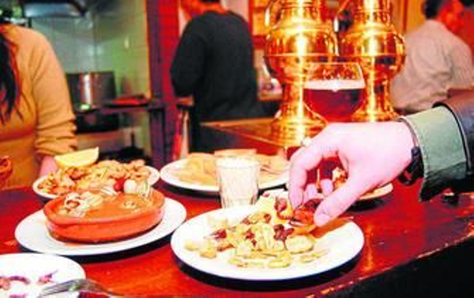 Dos jóvenes comen en un bar los platos más típicos.