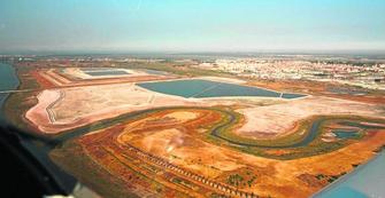 Las balsas de fosfoyeso vistas desde el cielo con la ciudad al fondo.