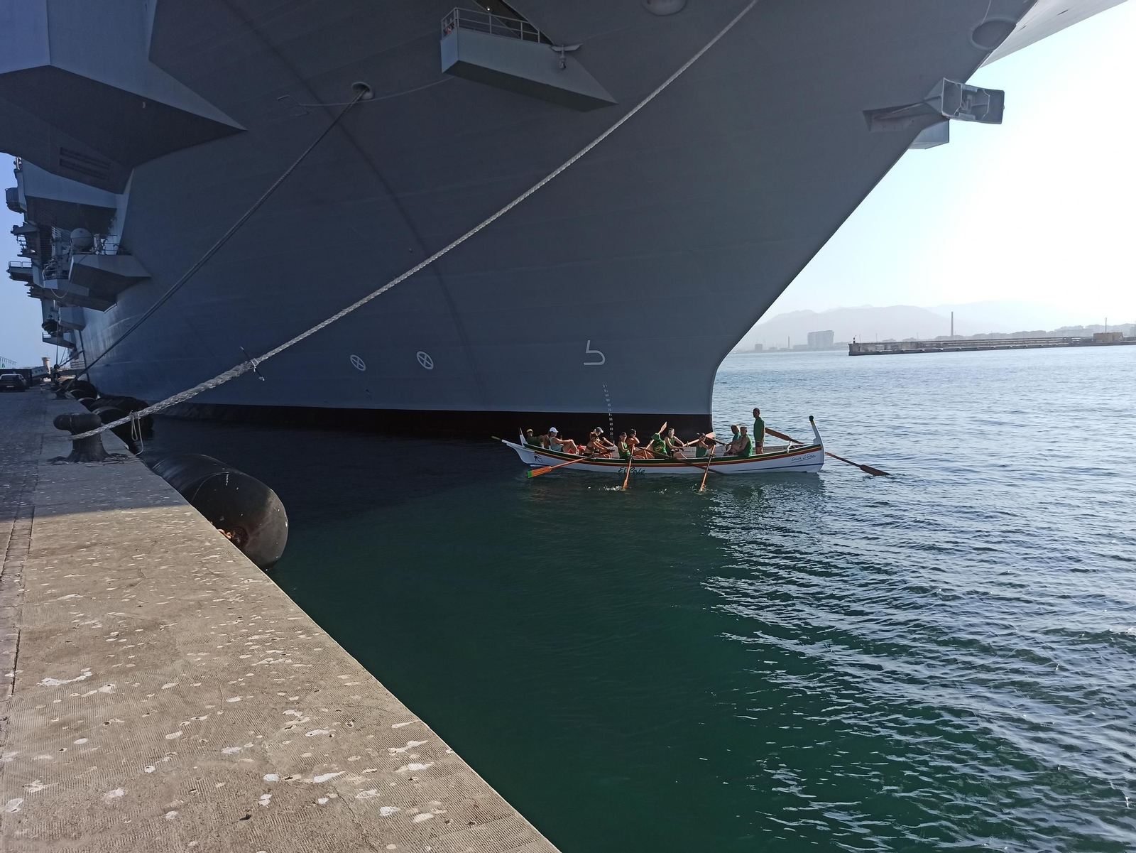 Barca de jábega&nbsp;junto a la proa del buque de guerra italiano 'Trieste'.