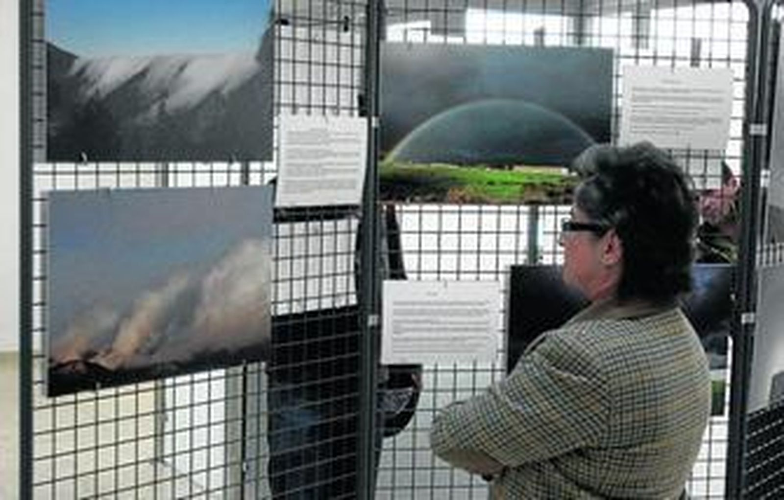 Una mujer observa algunas de las imágenes que componen la exposición.