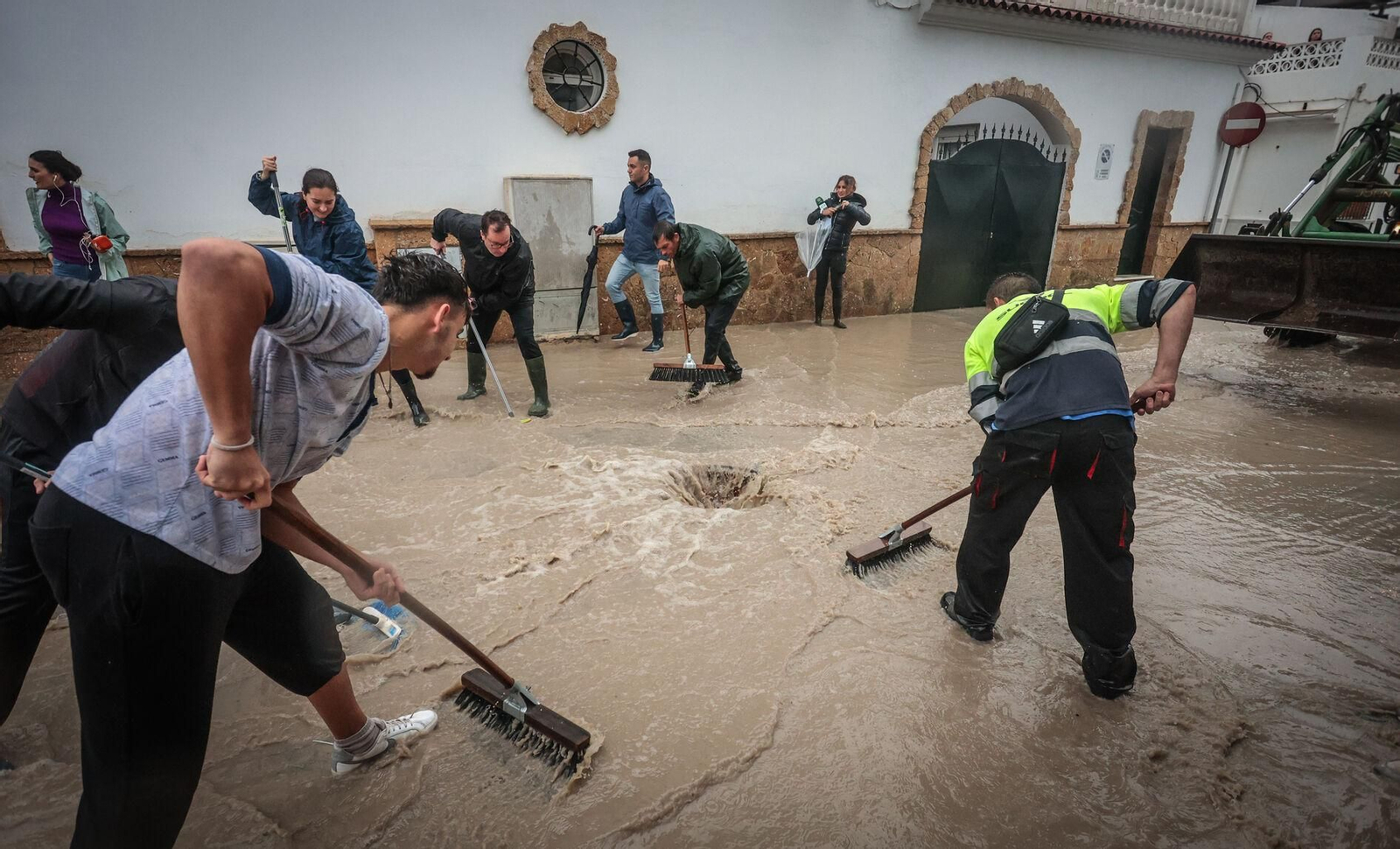 Vecinos evacuando agua de una calle anegada de Jerez. Vecinos evacuando agua de una calle anegada de Jerez.