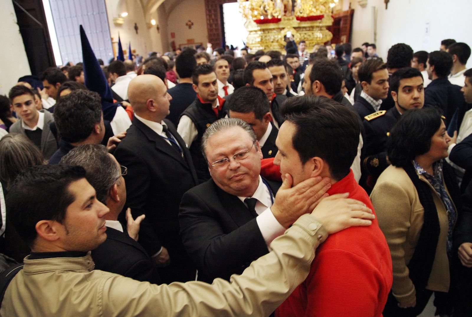 Paco Yesa abraza a un costalero tras la suspensión, por lluvia, de la salida de la Virgen de la Amargura.