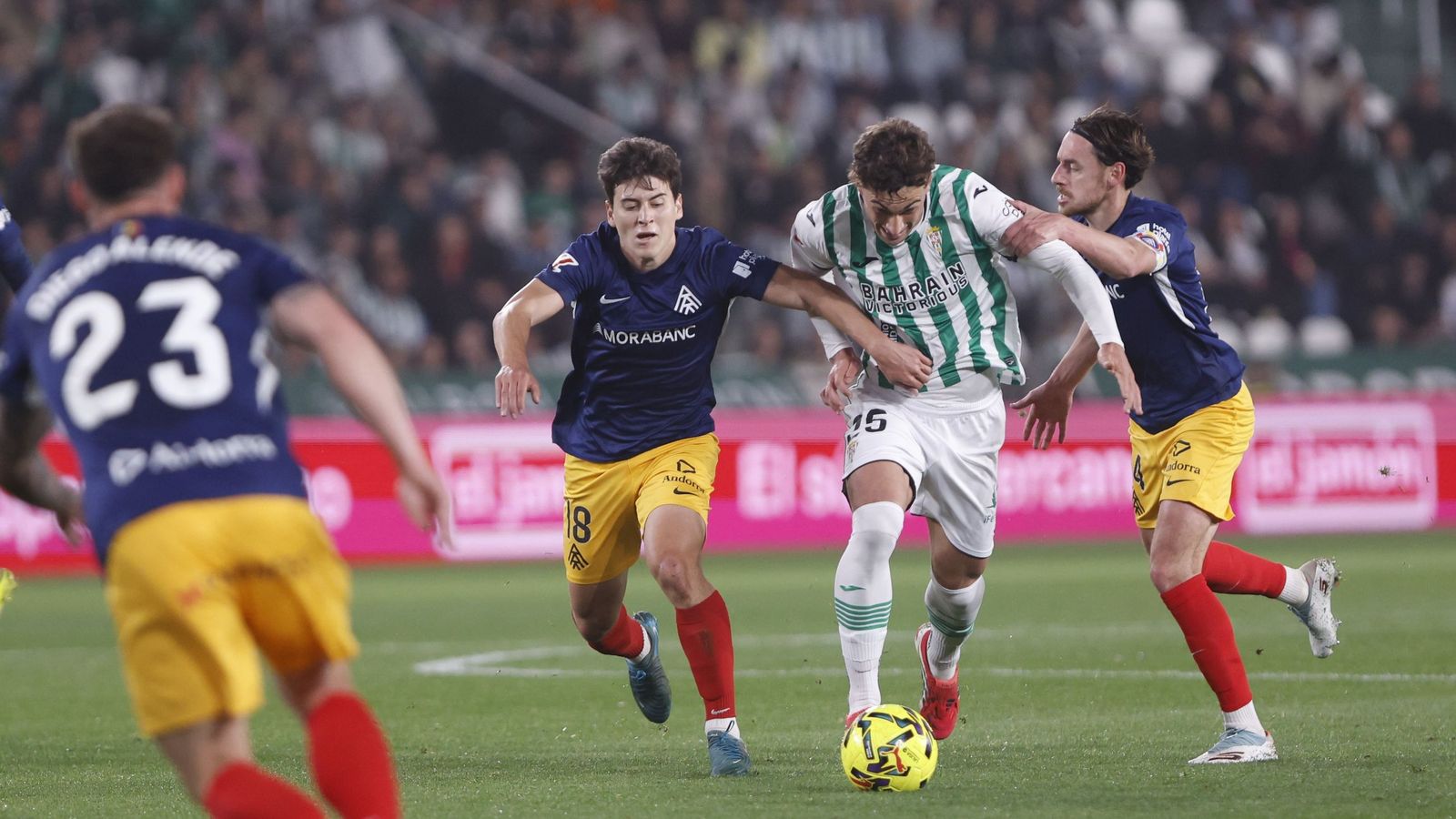 Mikel Goti, mediapunta del Córdoba CF, se cuela entre dos jugadores del Andorra.