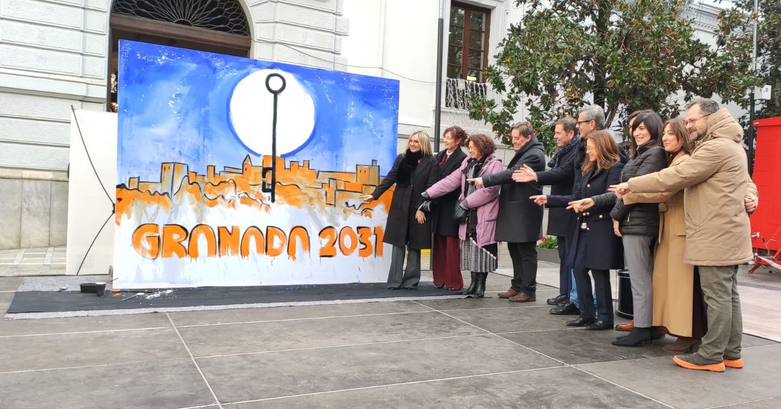 Miembros del Consorcio de la Capitalidad junto al mural realizado en directo para Granada 2031.