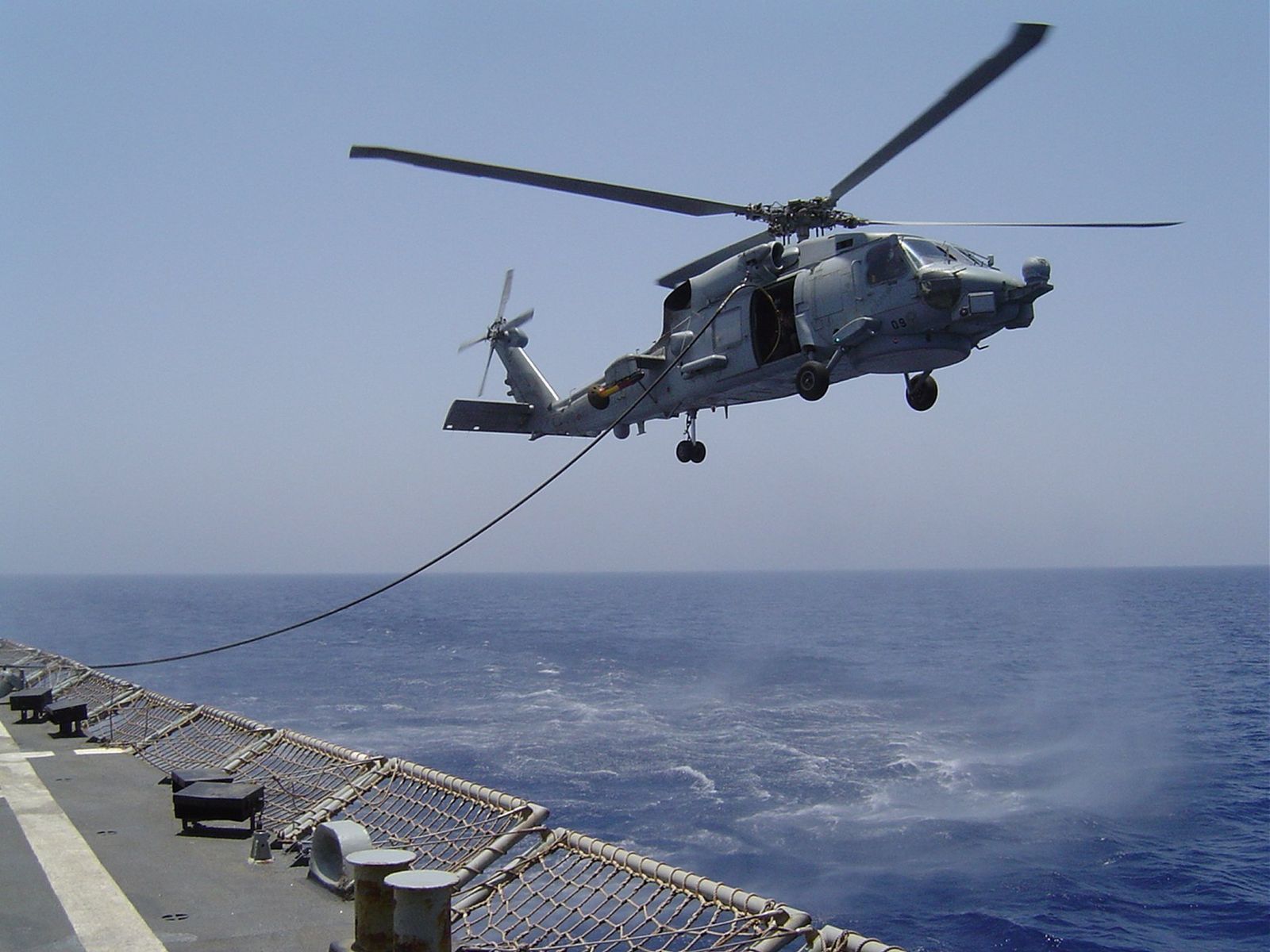 Uno de los SH-60F Seahawk actualmente operativos en la Armada española se reabastece de combustible desde un buque mientras permanece en vuelo.
