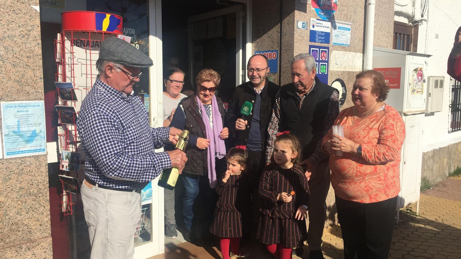 Pepe Delgado abre una botella de champán para celebrar los siete décimos que había comprado del Gordo en Benajarafe.