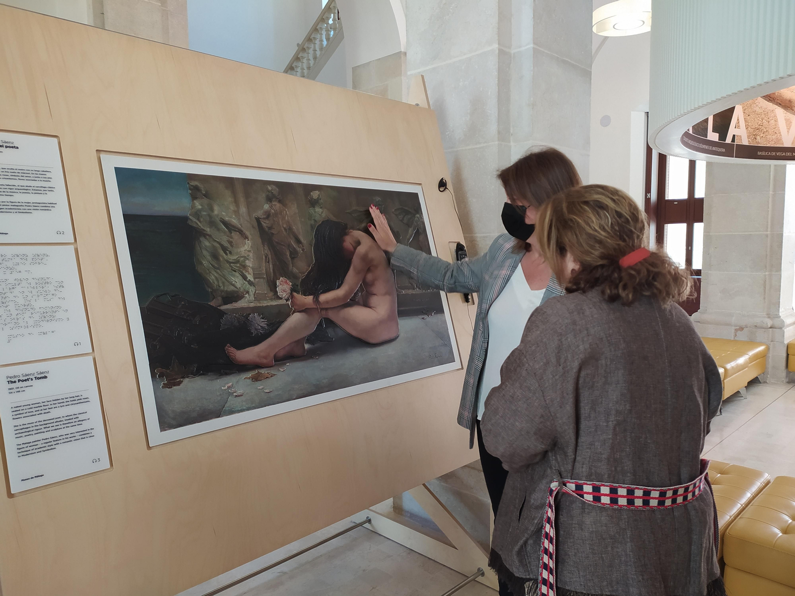 Carmen Casero, delegada territorial de Cultura y Patrimonio Histórico, y María Morente, directora del Museo de Málaga, observando el cuadro "La tumba del poeta" de Pedro Sáenz Sáenz, durante la presentación de "Hoy toca el Padro".