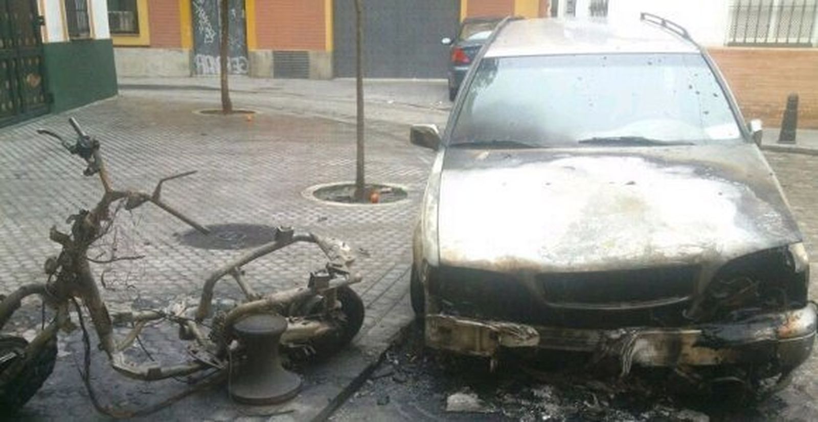 Arden una moto y un coche frente a la casa hermandad del Gran Poder