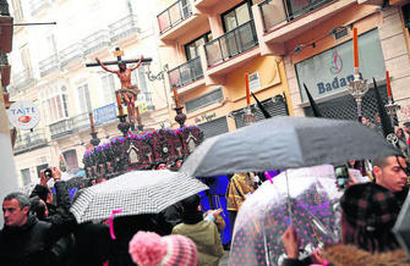 Paraguas al paso del Cristo de la Crucifixión, ayer, en el centro.