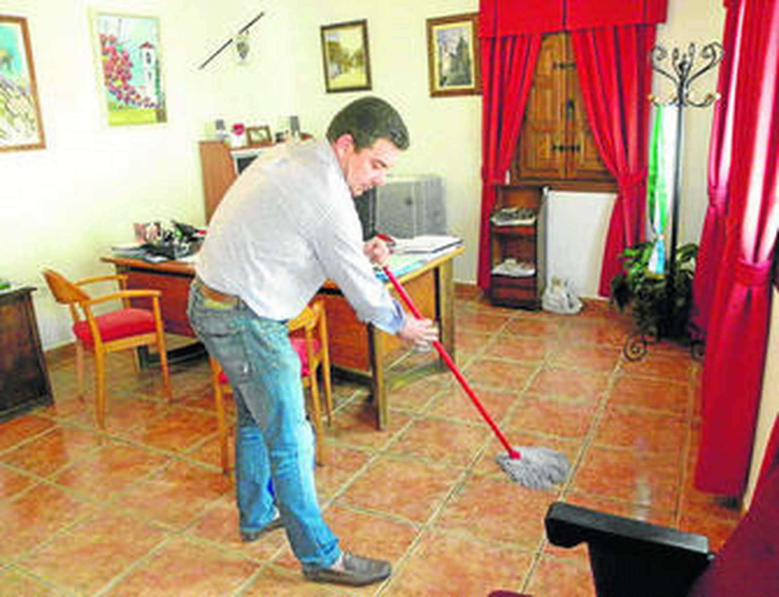 El alcalde de El Borge limpia su despacho con una fregona.