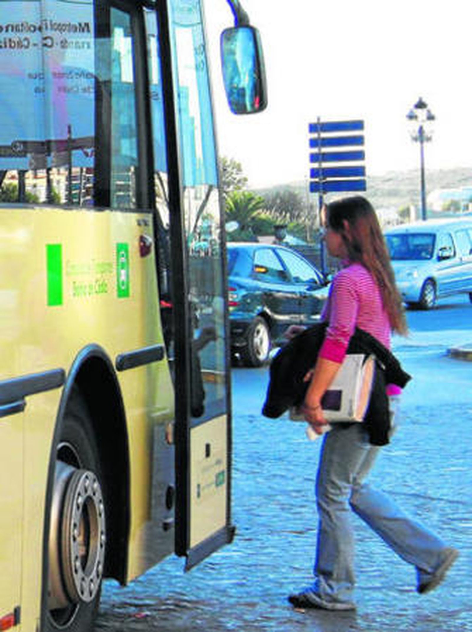 Una estudiante sube a un autobús interurbano en la plaza Andalucía.