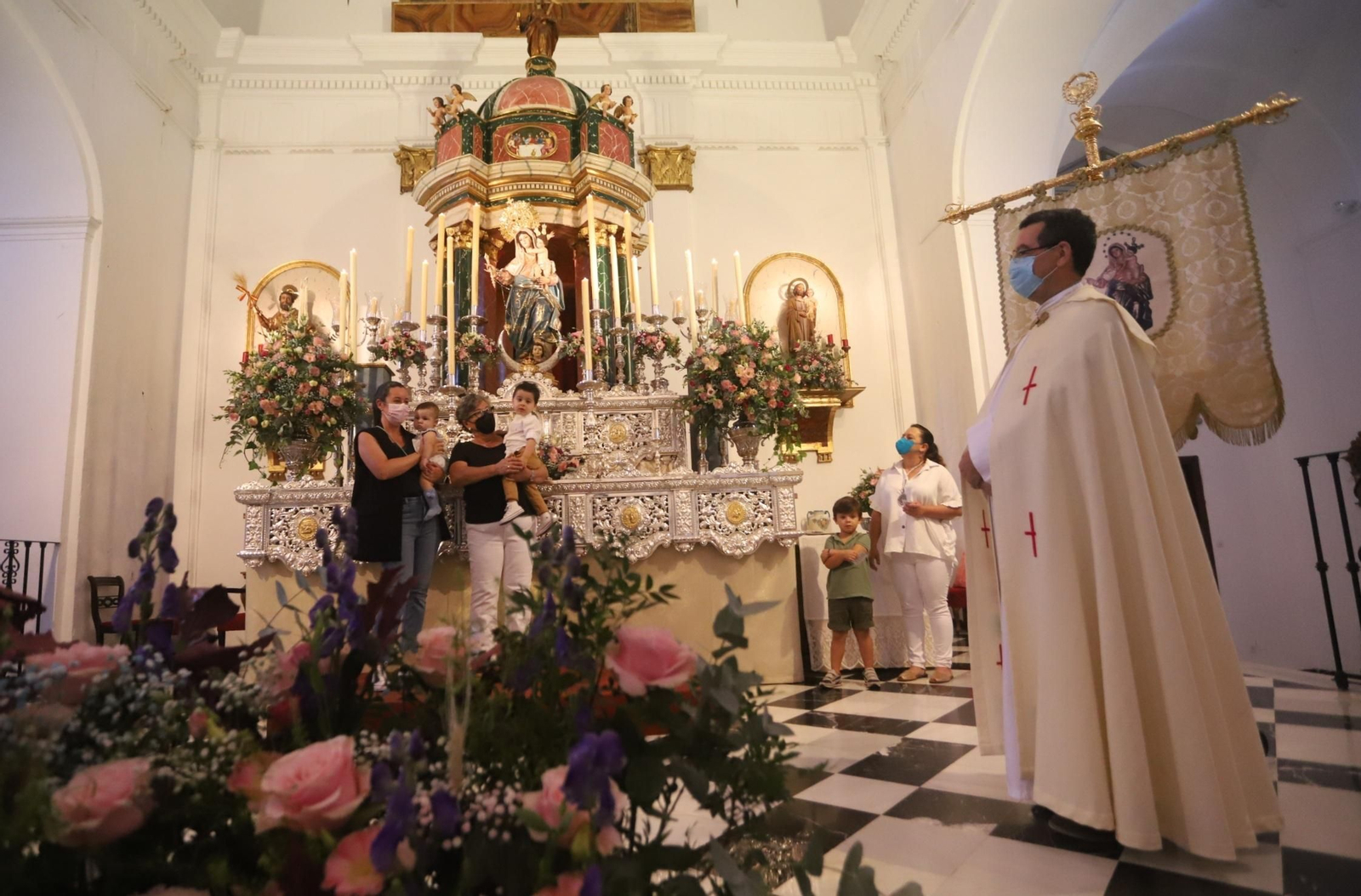 Una de las familias se hace una foto junto a la Virgen, este sábado.