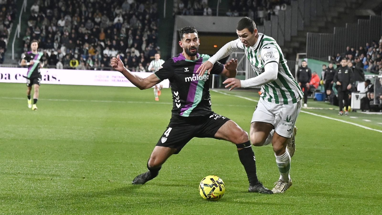 Adri Fuentes trata de ganar el balón ante Einar en el Córdoba CF - Málaga.