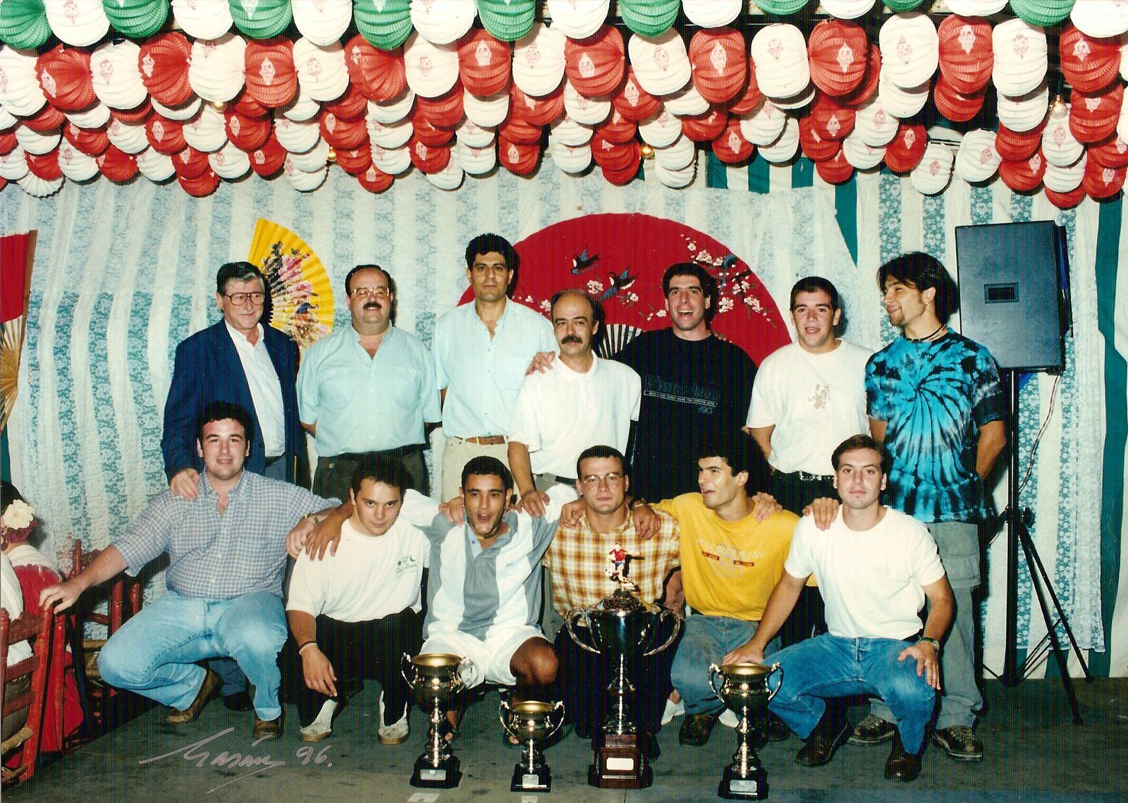 Serrano, en el centro de pie, con algunos jugadores del club en la Velá de Triana de 1996.